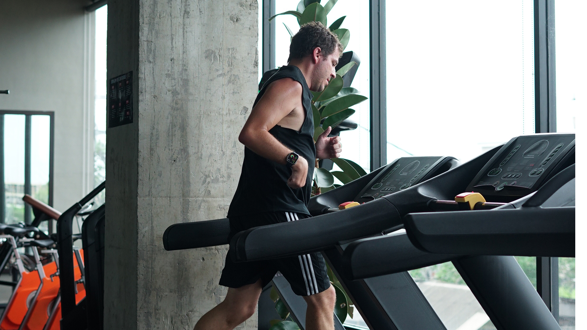 Pria berlari di atas treadmill saat latihan kardio di Surya Gym Bali