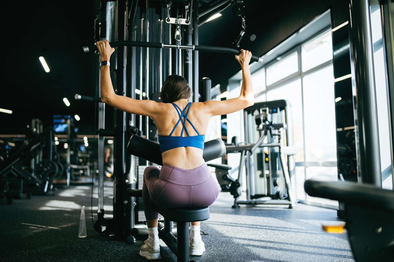 Woman performing a lat pulldown during her strength training classes in Bali.