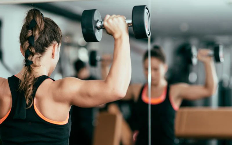 coach explaining weekly strength training Canggu program structure for beginner members